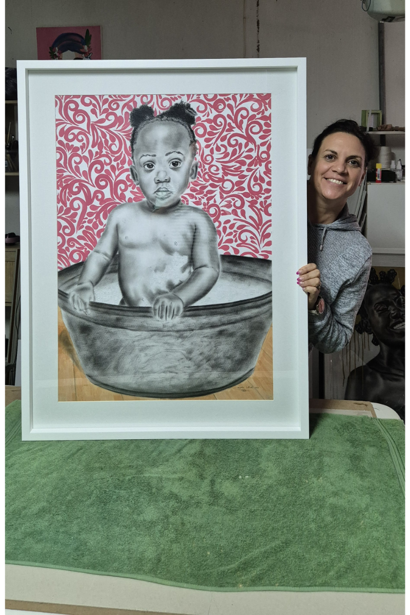 Squared Spacing holds up artwork of a little girl after it has been framed with a white frame.