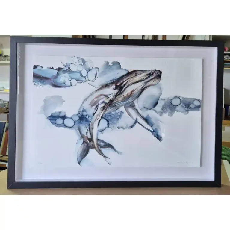 An artwork of a humpback whale with a black wooden frame.