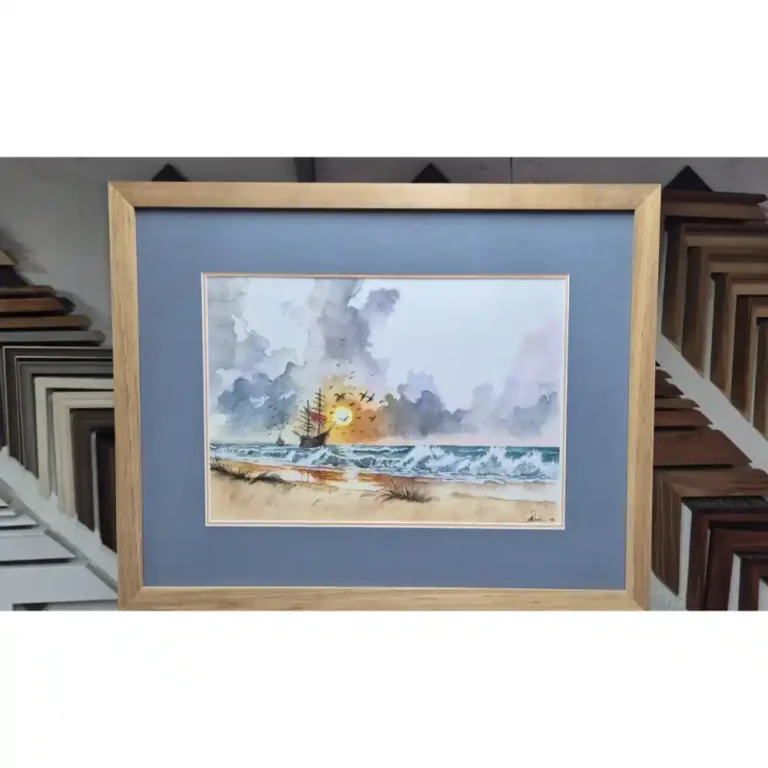 A watercolour painting of a sunset with a ship that is framed with a wooden border.